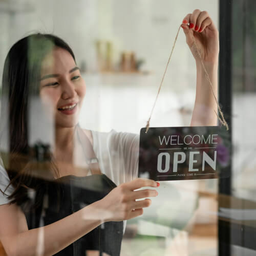 Business owner putting a sign on a window